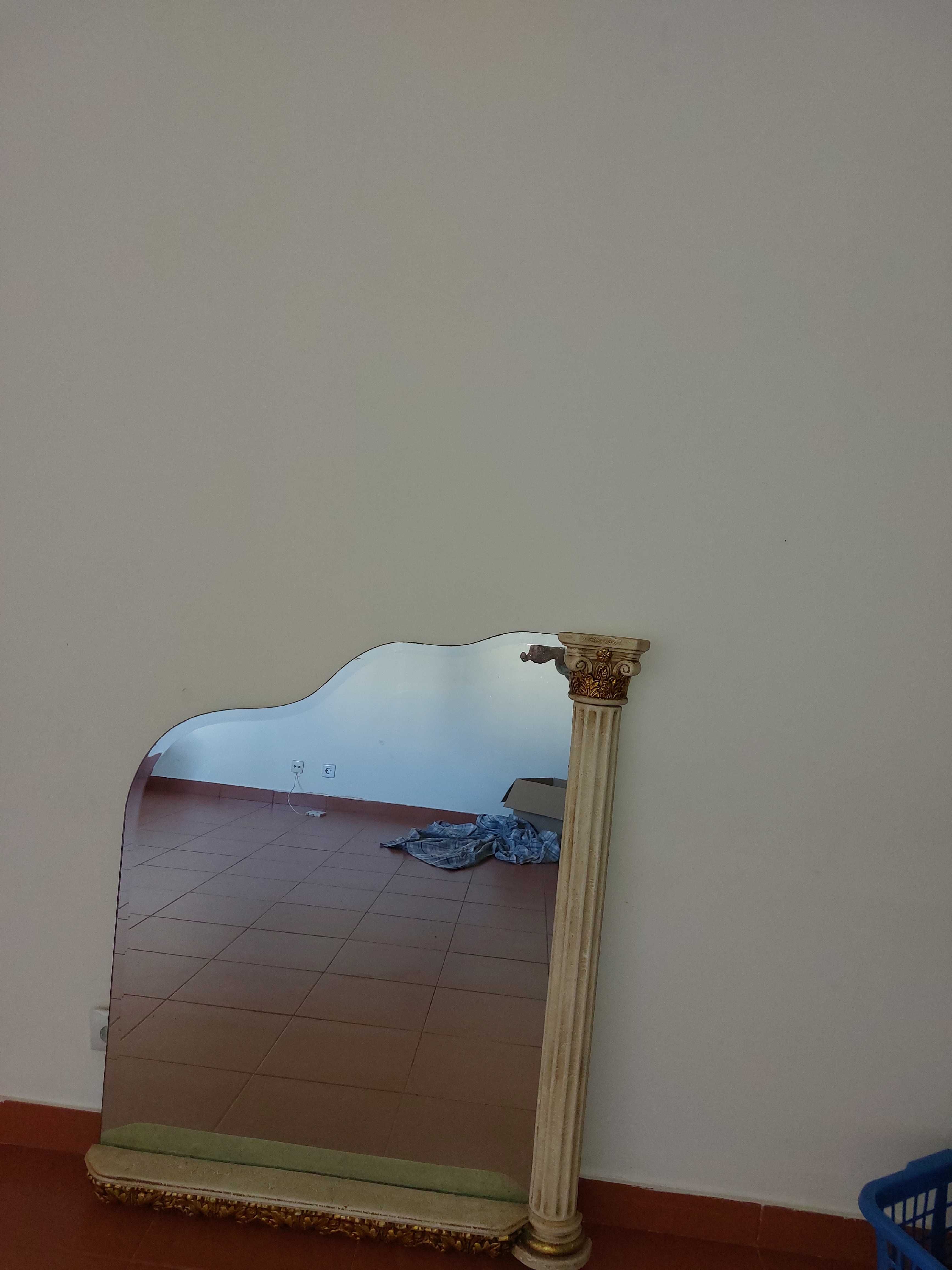 Espelho com moldura dourada .
