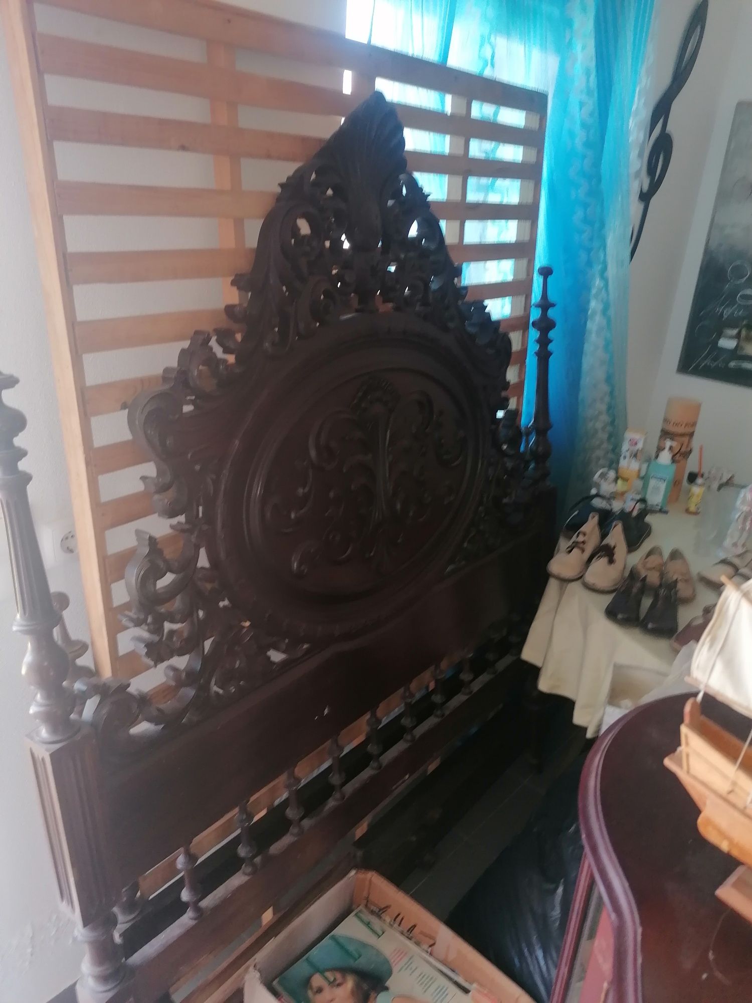 Cama antiga e pequena cristaleira