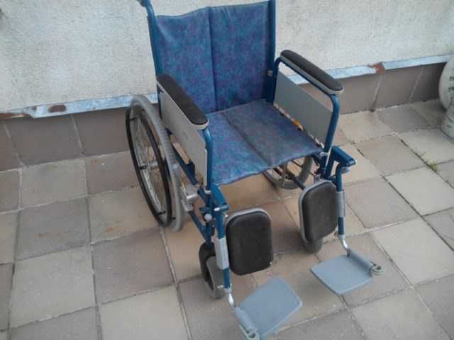 Wózek inwalidzki z podpurkami na nogi podnoszone.