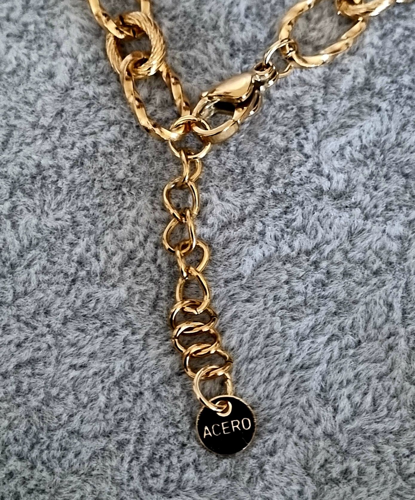 Colar dourado, em aço, com libelinha e mais 4 pingentes.
