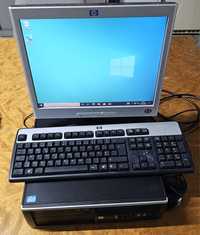 Computador escritório HP com ecrã, teclado e rato.