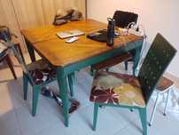 Mesa verde e castanha com cadeiras com almofadas de veludo estampado