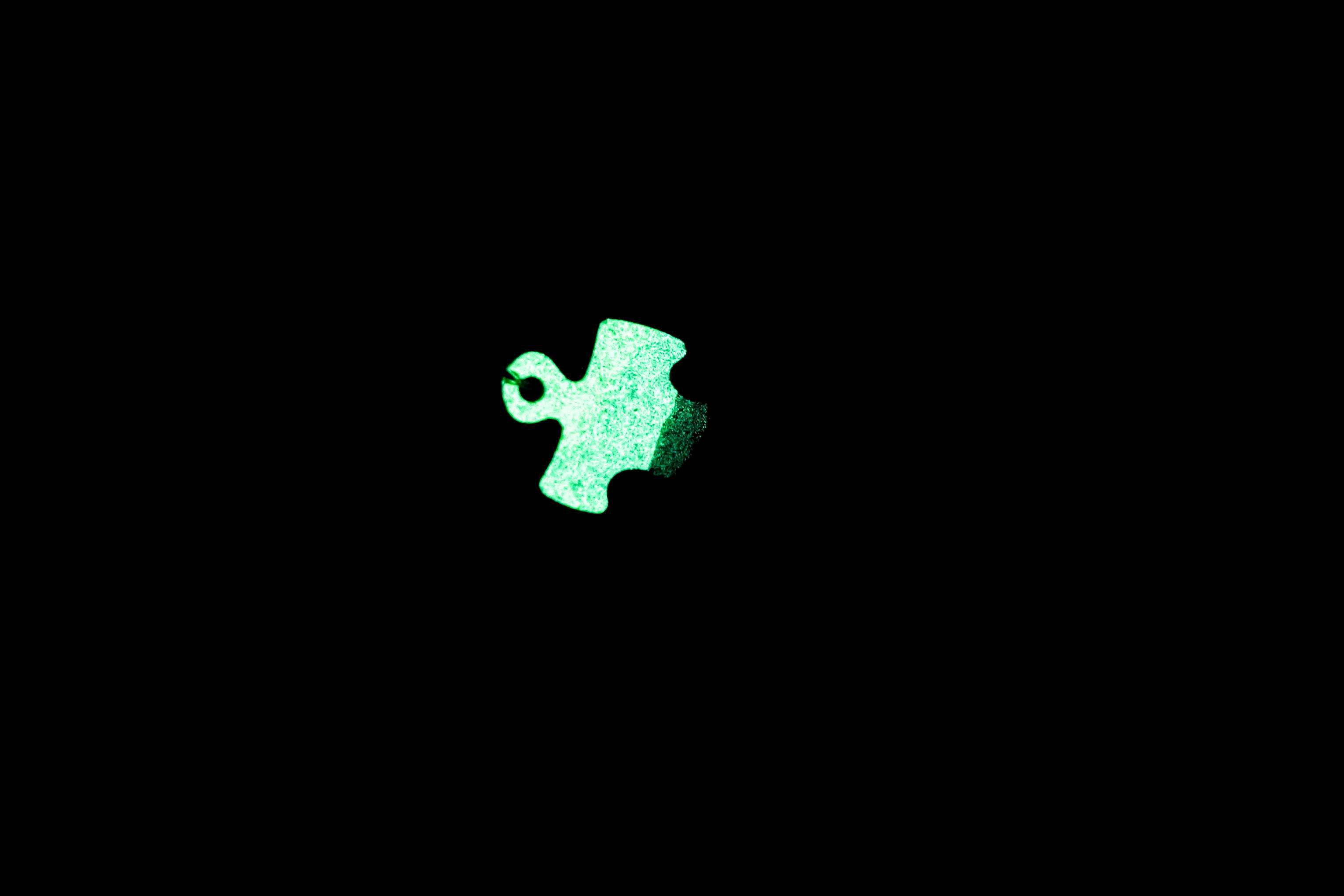 Wisiorek puzzel zielono - czarny świecący w ciemności i UV