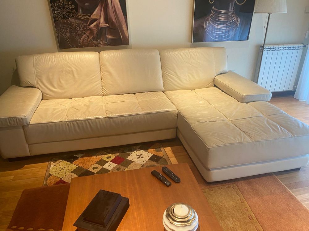 Sofá branco com chaise long em pele.