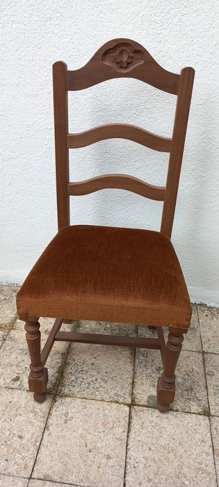 Cadeira em madeira com assento forrado em castanho escuro.
