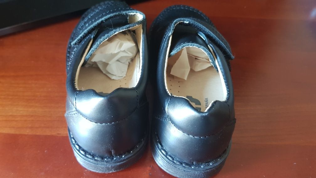 Sapatos novos de criança em pele