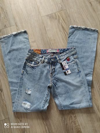 Nowe modne spodnie jeansy z przetarciami i aplikacją