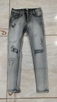 Spodnie jeansowe z aplikacjami i dziurami.