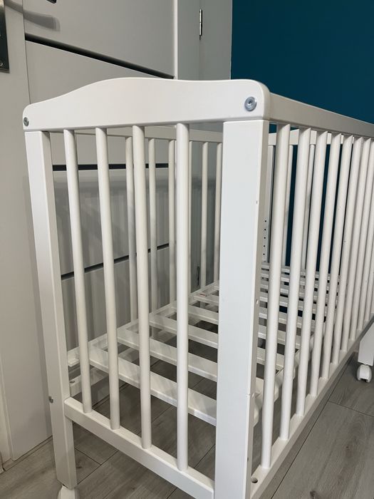 Małe łóżeczko dziecięce niemowlęce drewniane na kółkach z materacem