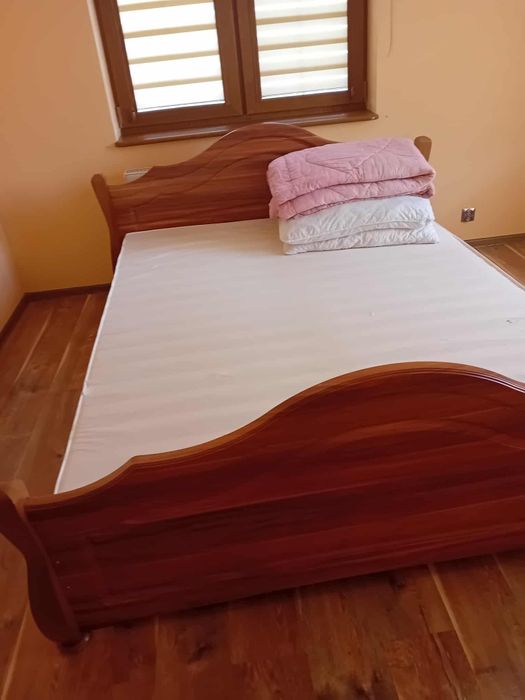 Łóżko z materacem i 2 stolikami nocnymi oraz lampkami nocnymi