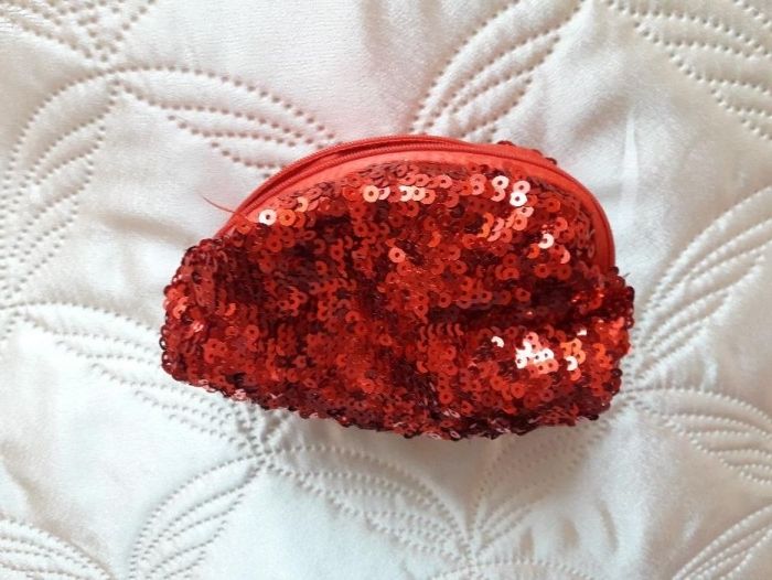 Kosmetyczka czerwona zdobiona cekinami używana na drobiazgi