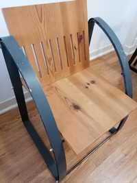Cadeira em madeira de pinho e braços de ferro.