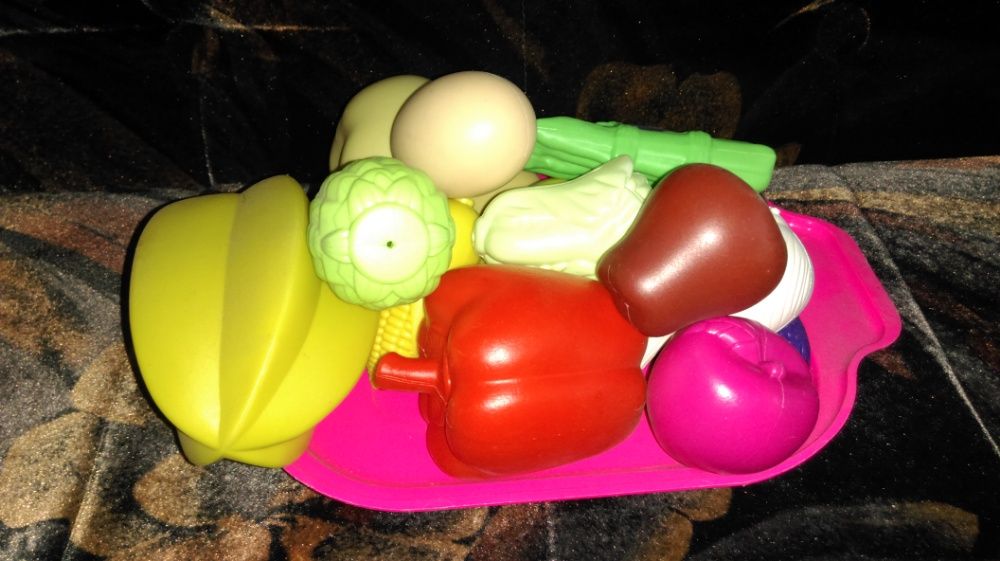 Набор детских игрушечных овощей и фруктов на подносе.