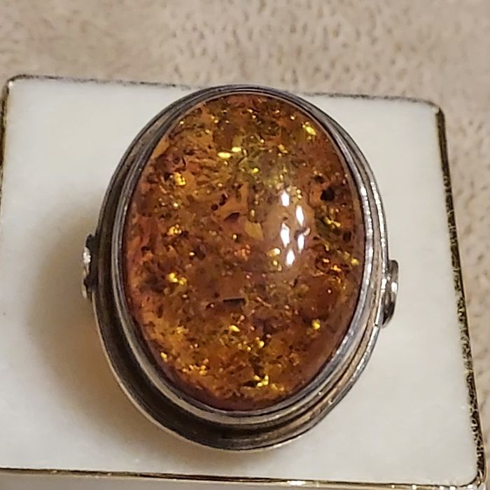 Duzy srebrny pierścionek ze złocistym bursztynem.