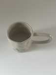 Kubek ceramiczny wzorowany na handmade pogięty beżowy z długim uchem