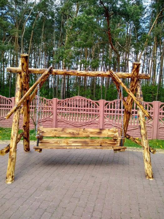 Huśtawka ogrodowa, drewniana z siedziskiem dla dziecka lub daszkiem.