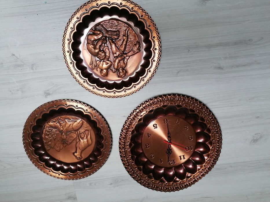 Pratos decorativos em cobre, sendo que um é relógio de parede.