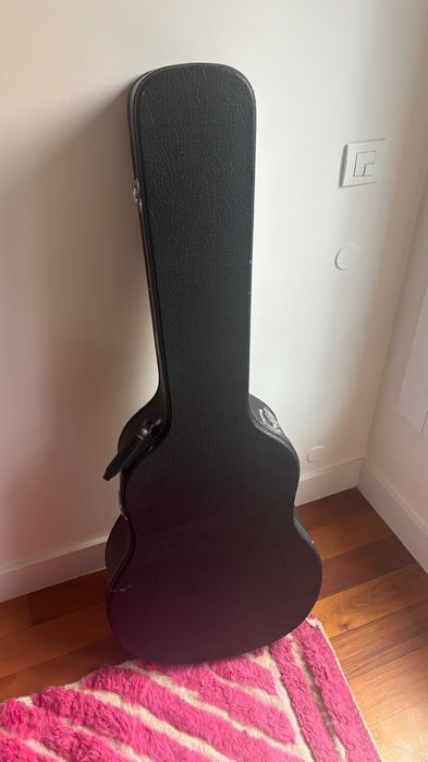 Violão acústico preto elegante com estojo rígido combinando.