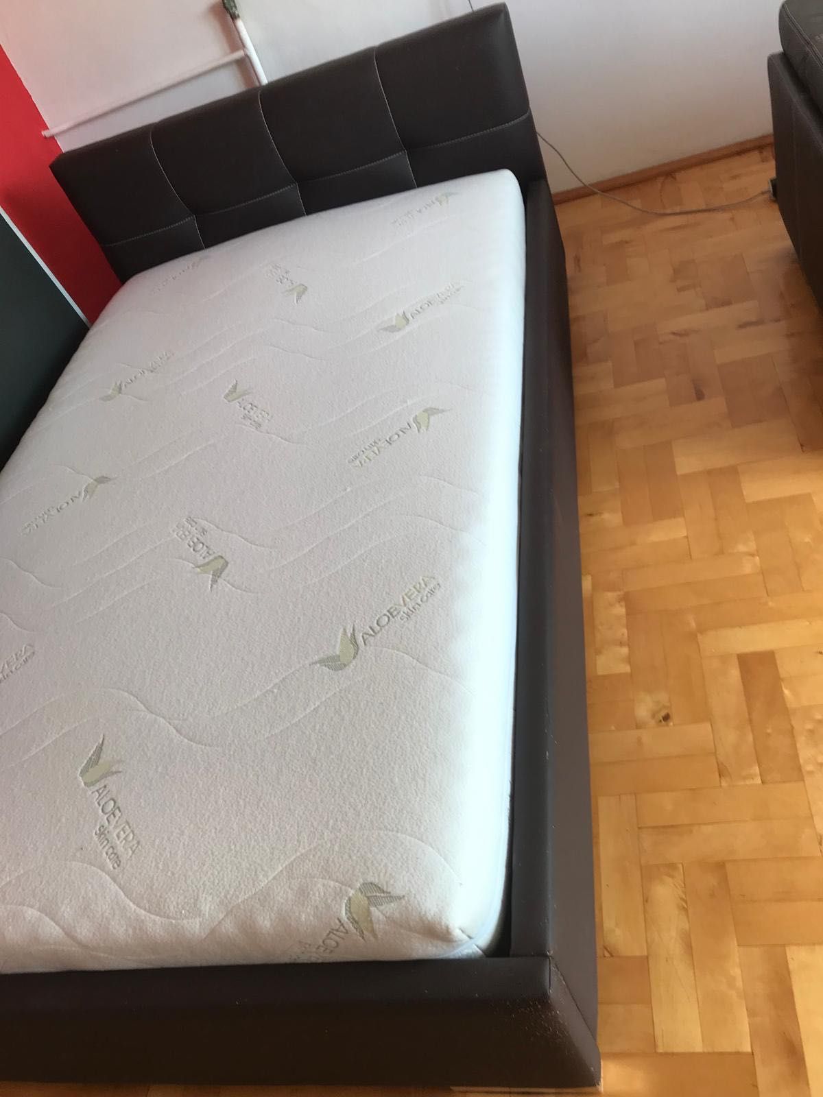 Łóżko podwójne z materacem i pokrowcem.