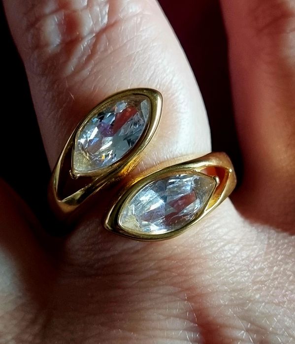Anel dourado, em aço, com 2 pedras de vidro transparentes. T19