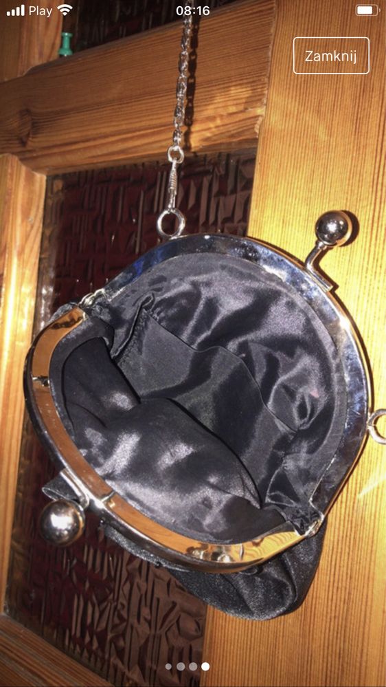 Czarna torebka z różą na srebrnym łańcuszku.