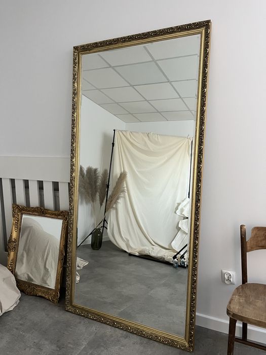 Duże lustro w złotej ramie