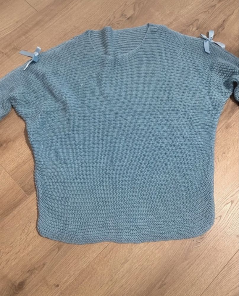 Niebieski sweter o kroju nietoperza z kokardkami