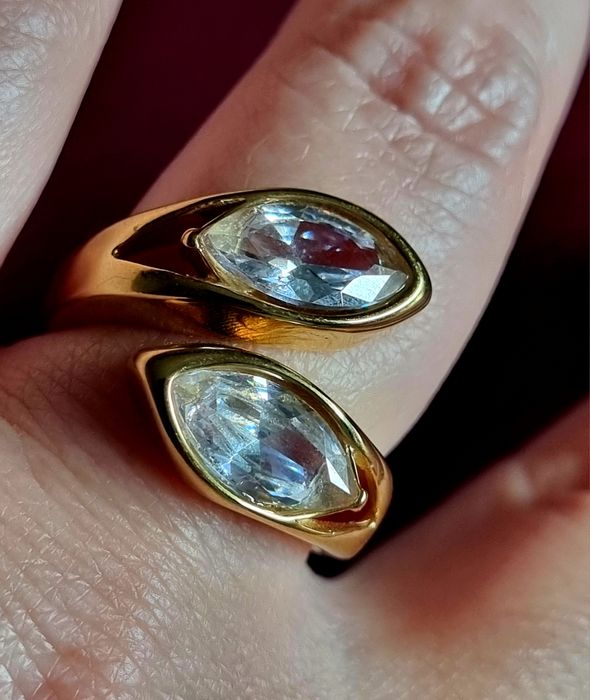 Anel dourado, em aço, com 2 pedras de vidro transparentes. T19