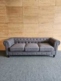 Szara materiałowa sofa Chesterfield