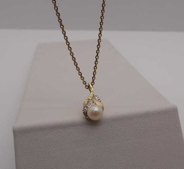 Delikatna złota zawieszka perła i diamenty.
