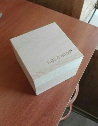 Ciemny drewniany zegarek w drewnianym pudełku na cienkim pasku