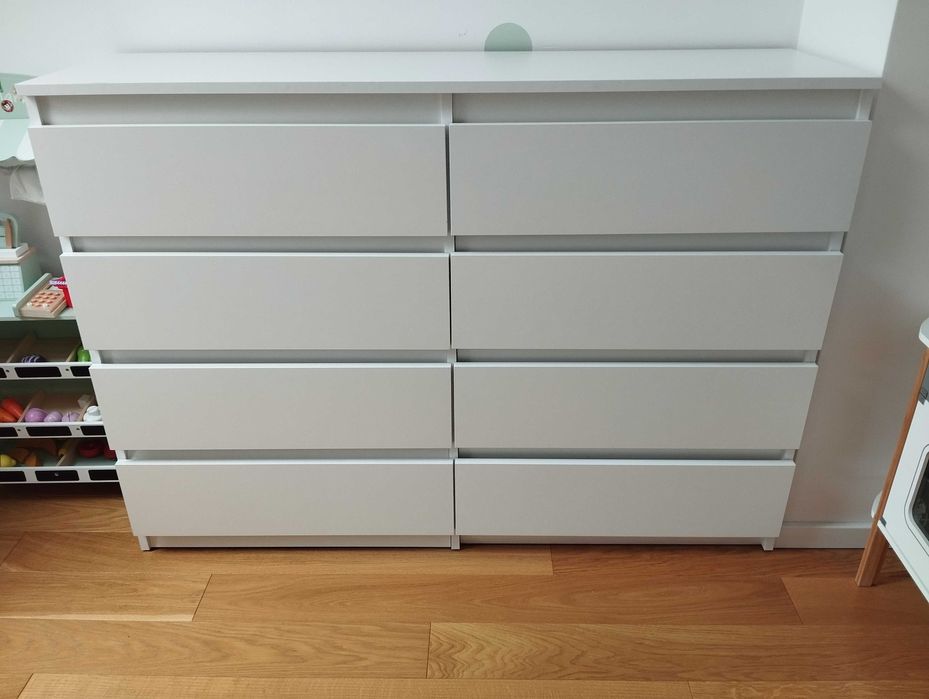 Biała komoda z 8 szufladami.