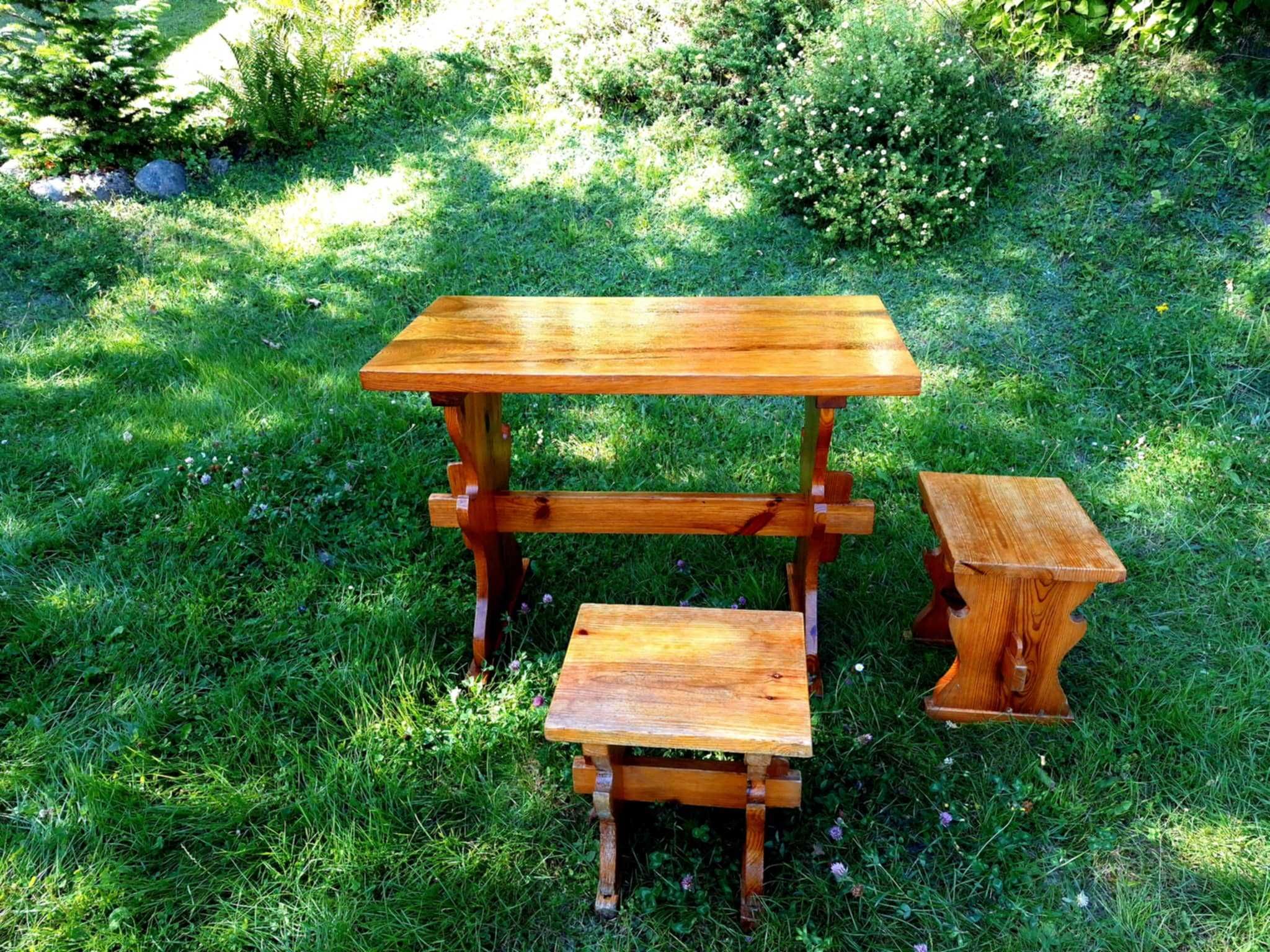 Drewniany stół i dwa taborety w góralskim stylu