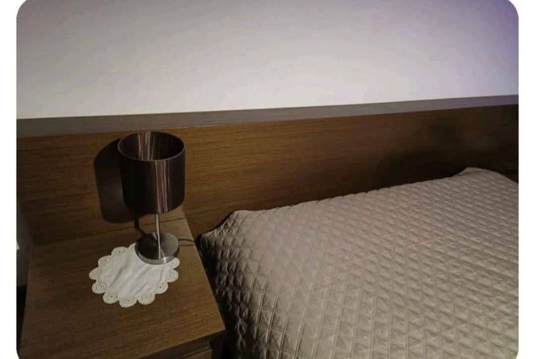Cama de casal com mesinhas de cabeceira.