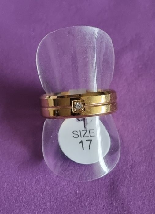 Anel/aliança dourado, em aço inoxidável, com 1 brilhante. T17