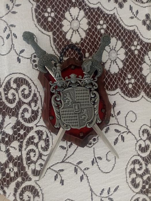 Brasão decorativo com duas espadas metálicas