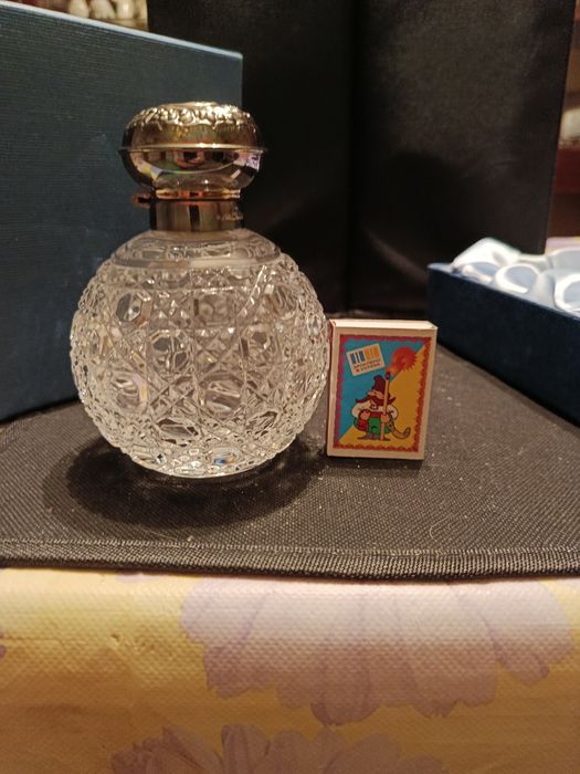 Флакон для духов с серебряной крышкой.