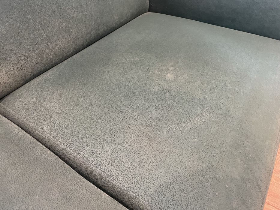 Zielona butelkowa sofa z funkcja spania z pufami i drewnianymi półkami