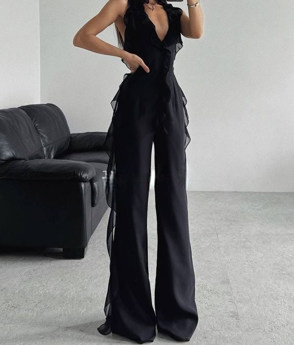 чорний комбінезон із шифоновими рюшами та глибоким вирізом