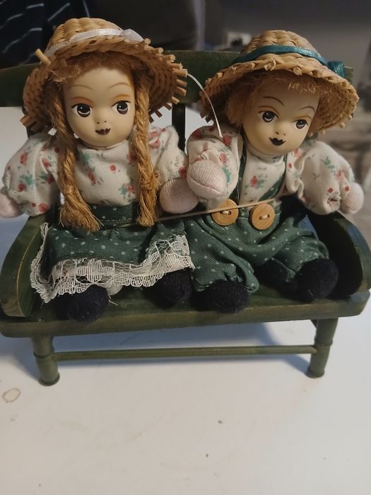 Stare zabawki lalki porcelanowe na ławeczce