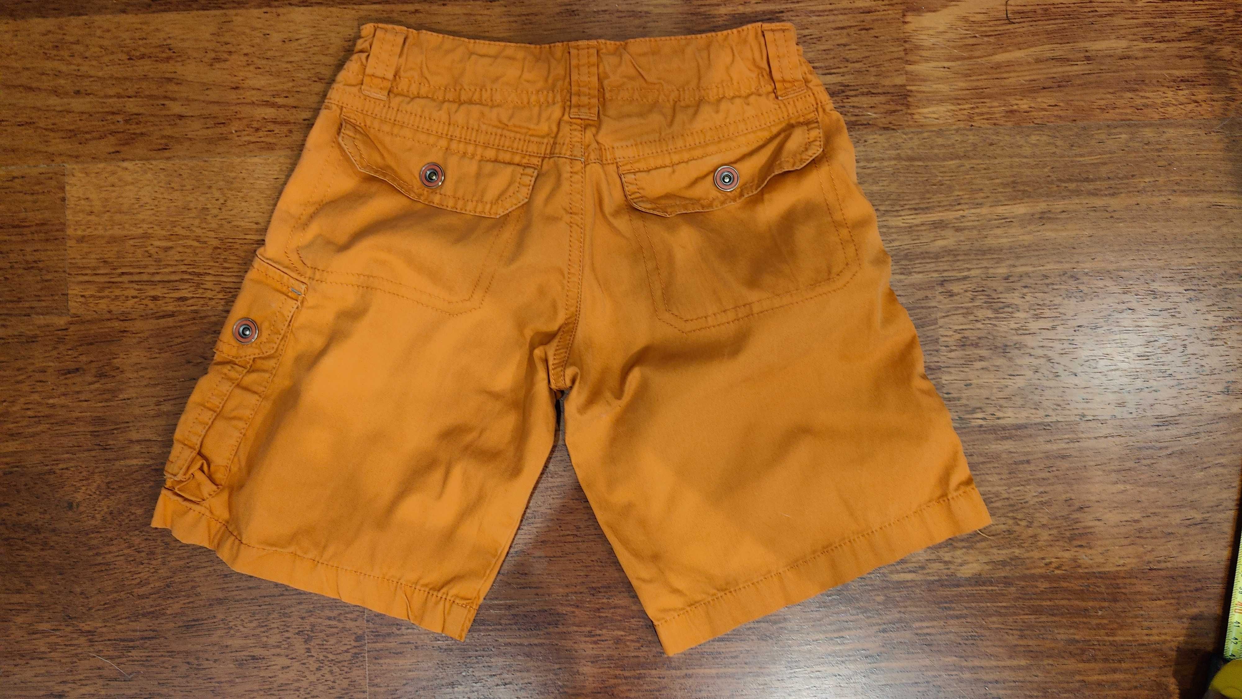 Pomarańczowe spodnie krótkie. Decathlon.