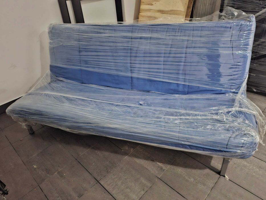 Sofá cama azul com duas almofadas