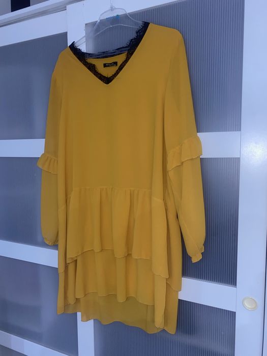 Musztardowa sukienka z koronkowym dekoltem i falbankami