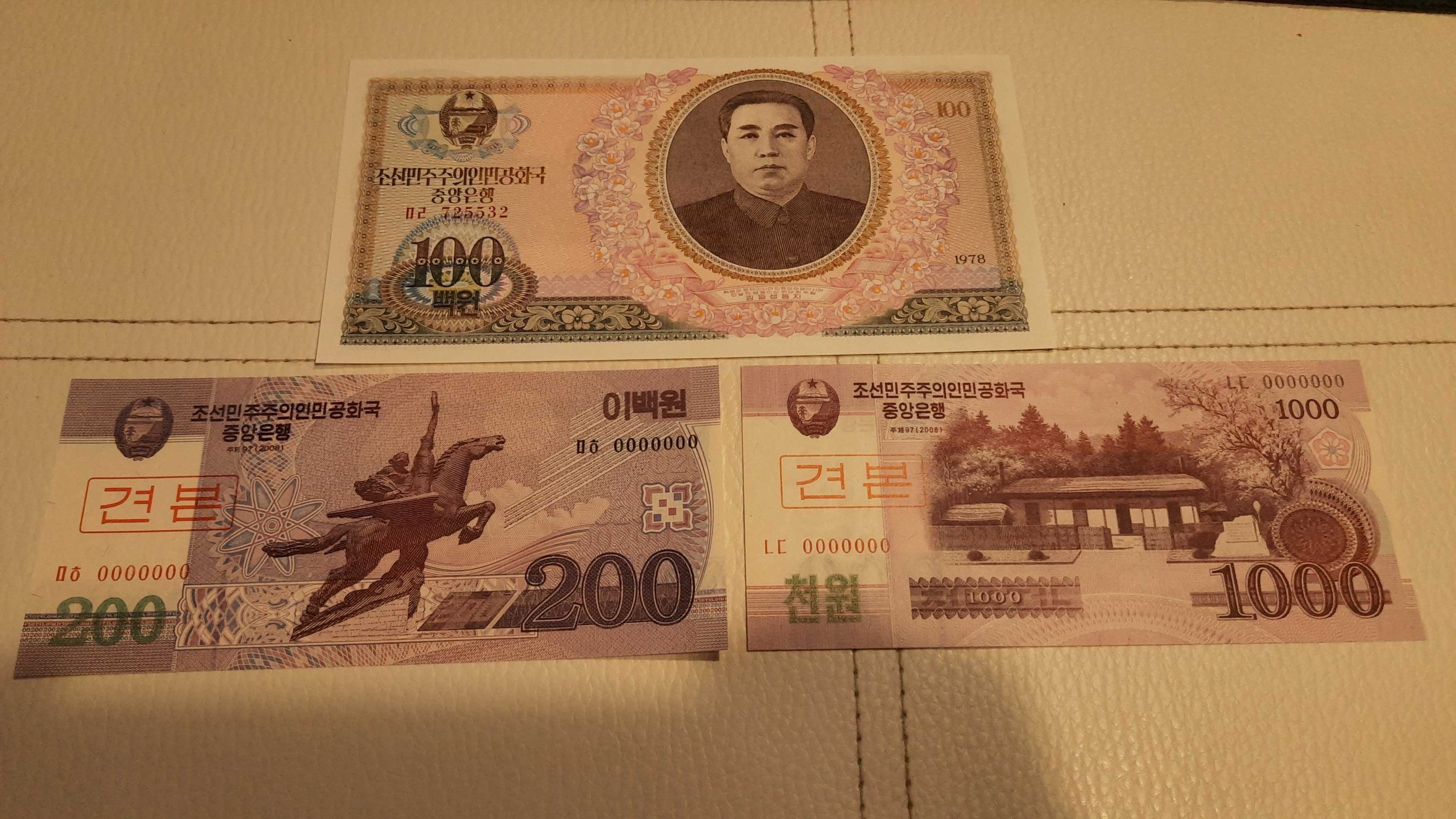 3 banknoty o nominałach 100, 200 i 1000 wonów północnokoreańskich