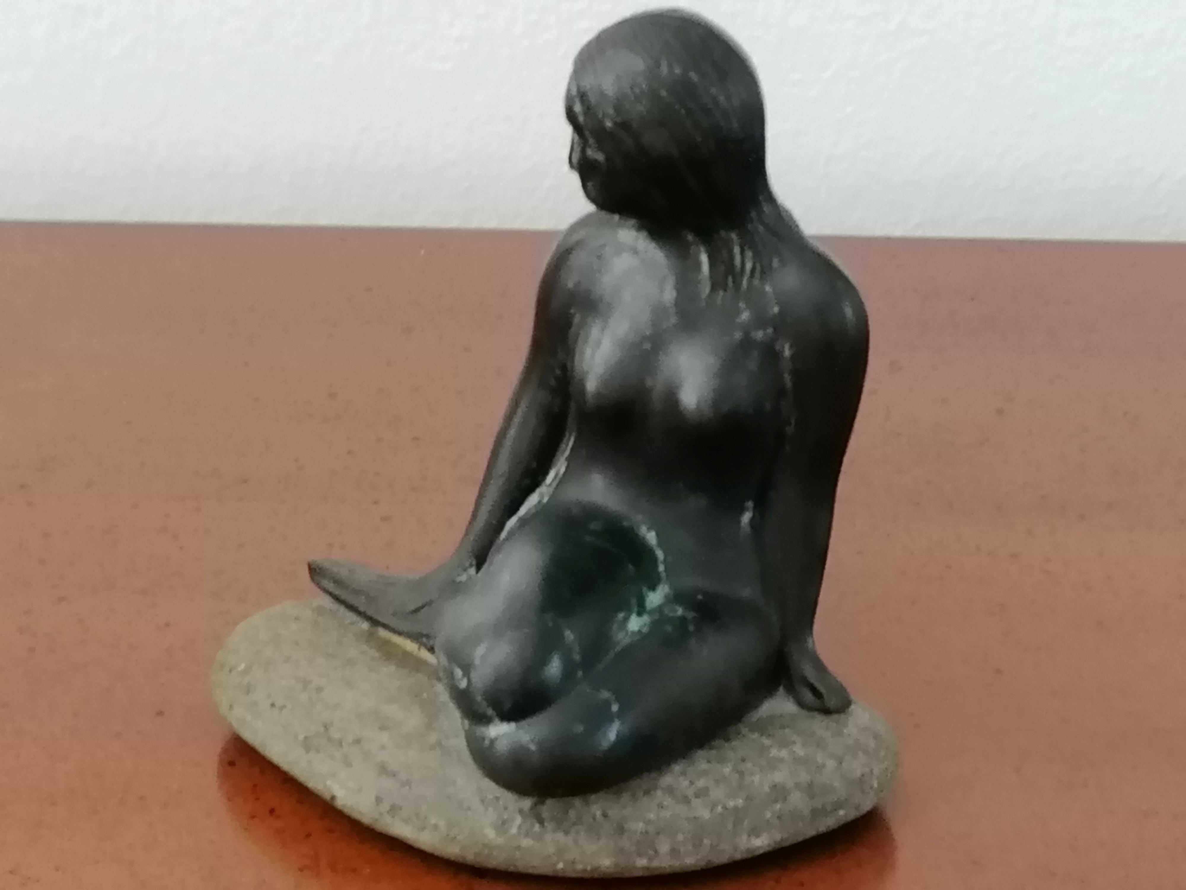 Escultura da pequena sereia em metal e com a base em pedra