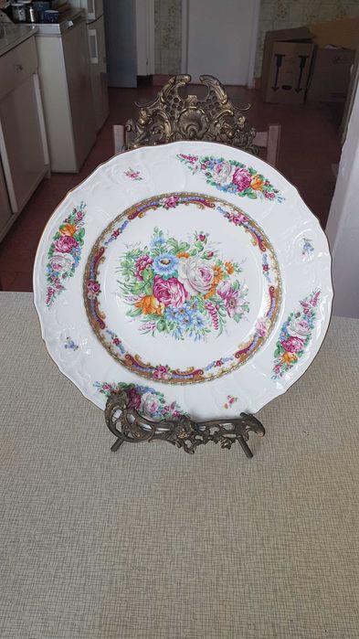 Prato decorativo em porcelana com motivos florais e borda dourada.