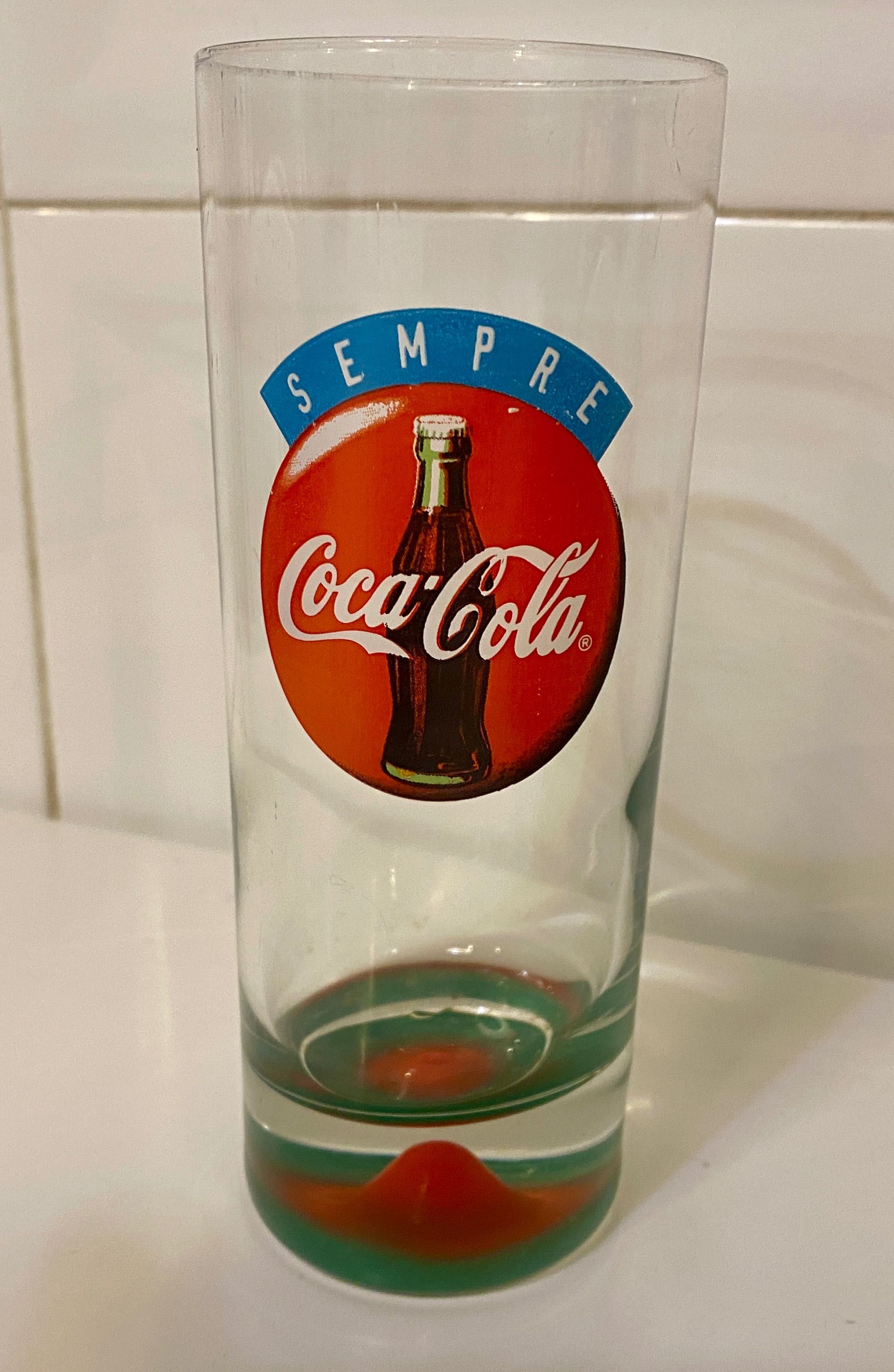 Copo antigo coca cola com relevo mama no fundo.