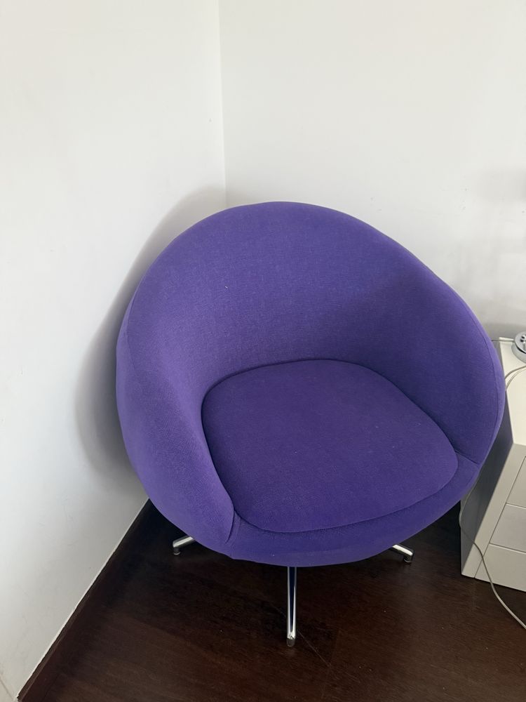 Cadeirão de tecido roxo.