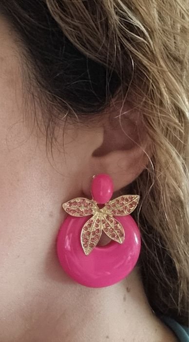 Brincos em acrílico, de pico, em rosa fucsia e apontamentos dourados.