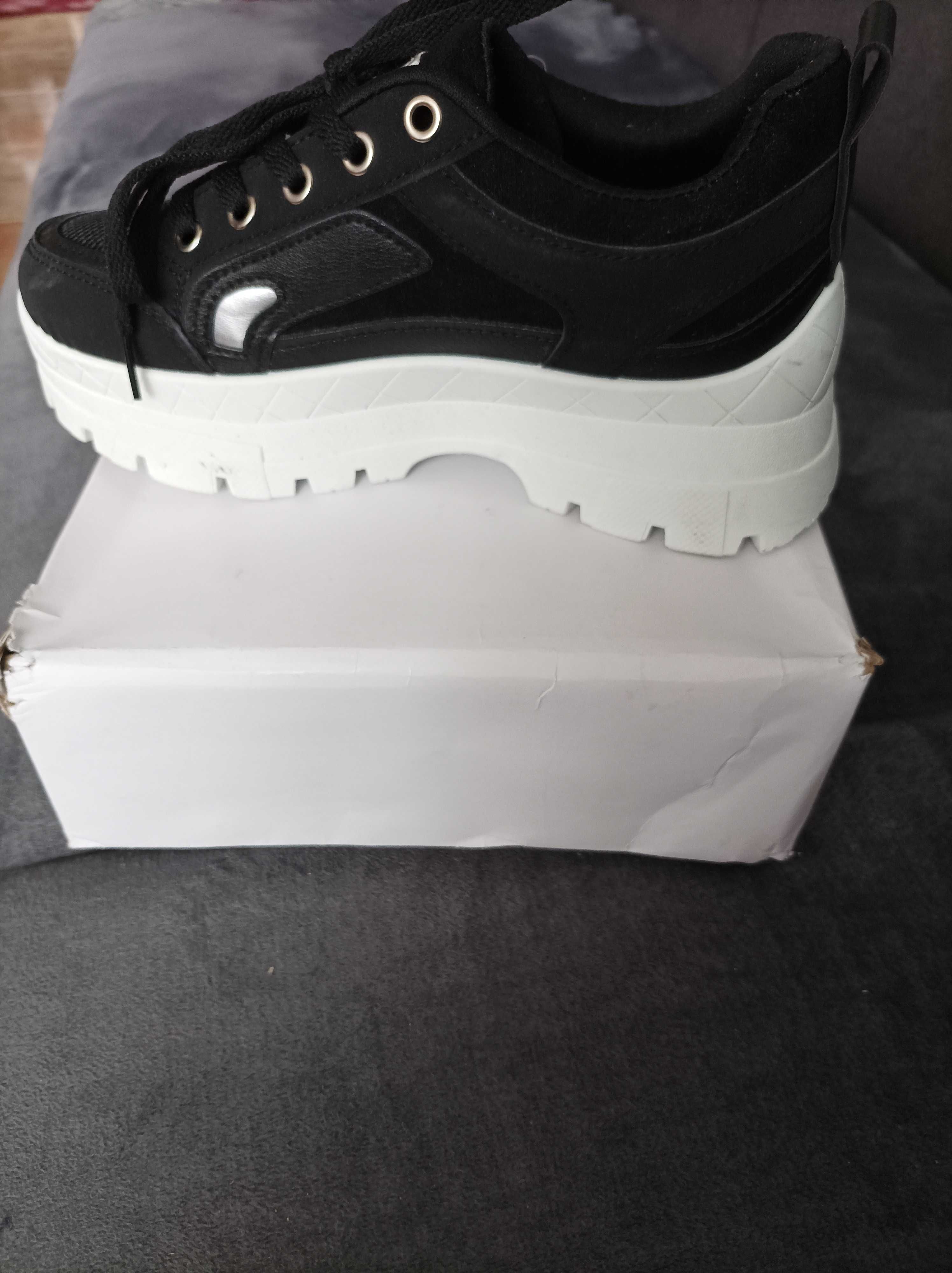 Buty sportowe sneakersy damskie czarne na białej podeszwie.